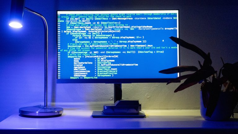 Developer workspace with monitors showing abstract quantum and compute visuals
